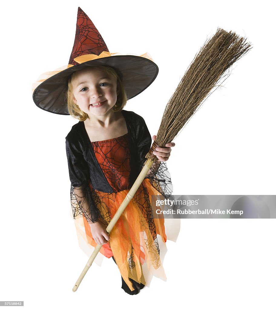 High angle view of a girl dressed as a witch holding a broom