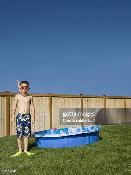 portrait of a boy wearing flippers and snorkel - zwembroek stockfoto's en -beelden