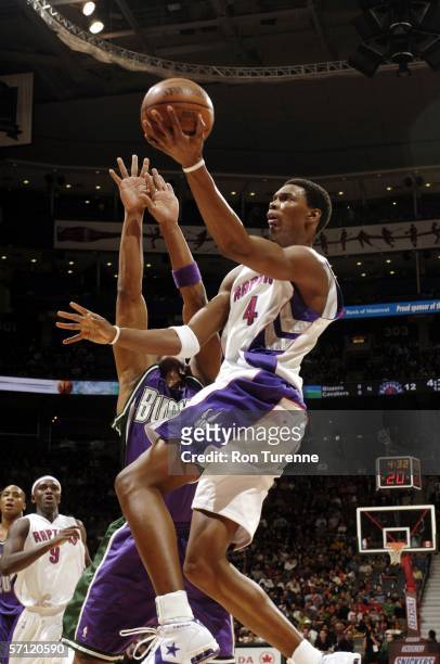 Chris Bosh of the Toronto Raptors drives past Maurice Williams of the Milwaukee Bucks on March 17, 2006 at the Air Canada Centre in Toronto, Canada....