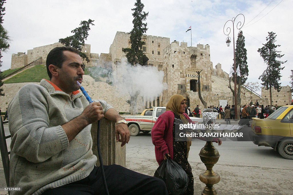 A man smokes his water pipe in front of