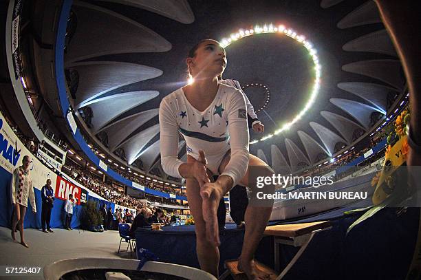 Brazil's Lais Souza puts some magnesia before performing at the uneven bars qualifying round, 18 March 2006 in Lyon, central eastern France, during...