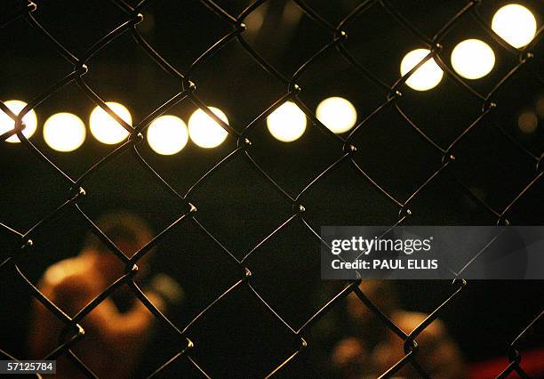 Manchester, UNITED KINGDOM: Two cage fighters confront eachother behind a wire cage during a match in the World Cage Fight Championships in...