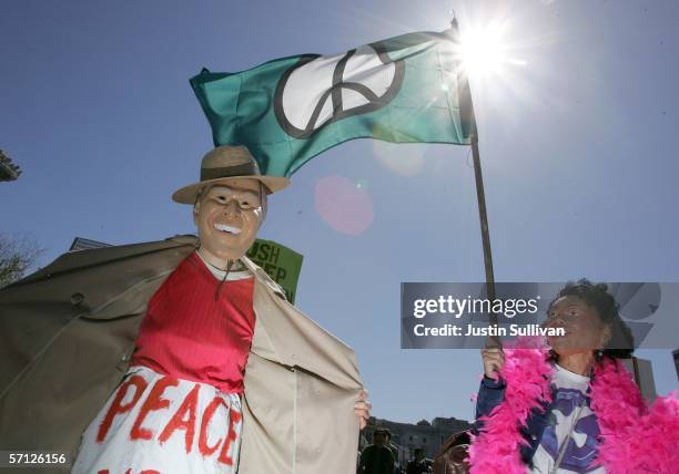 Person dressed as U.S. President George W. Bush flashes as a person dressed as Codeleeza Rice looks on during an anti-war demonstration March 18,...