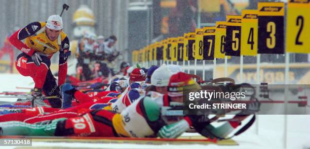 Raphael Poiree of France finishes shooting while other biathletes continue shooting during the men's 15 km mass start competition of the biathlon...