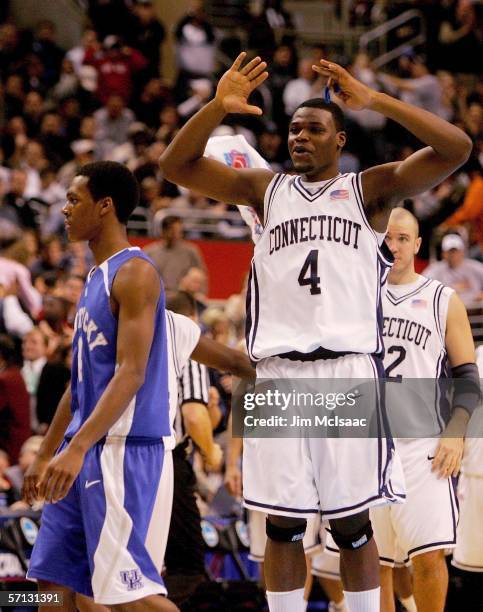 Jeff Adrien of the Connecticut Huskies celebrates their 87-83 victory over the Kentucky Wildcats as Rajon Rondon of the Wildcats walks off the court...