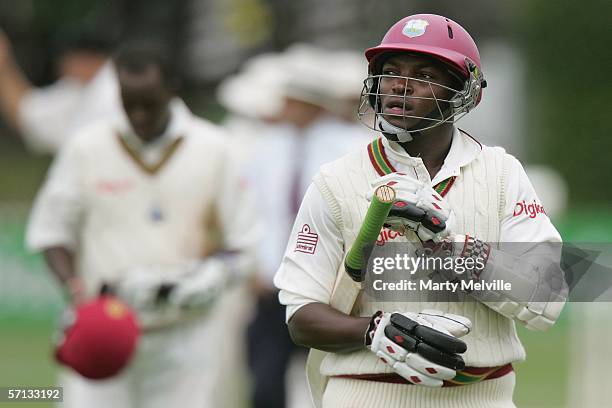 Rawl Lewis of the West Indies walks from the field with team mate Daren Powell after the end of the West Indies second innings of 215 all out during...