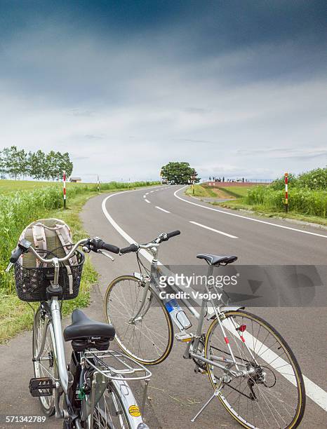 couple bicycle on the road, biei, hokkaido - biei town stock pictures, royalty-free photos & images