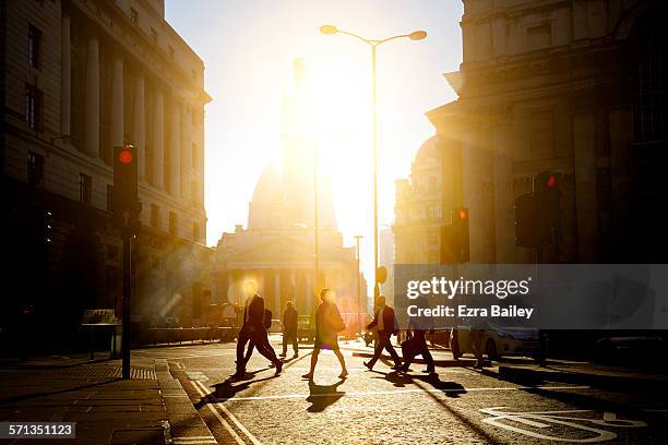 walking to work through the city at sunrise - auto ampel stock-fotos und bilder