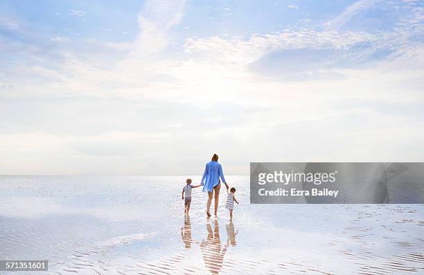 mother and children walking at low tide sunset. - criancas free imagens e fotografias de stock