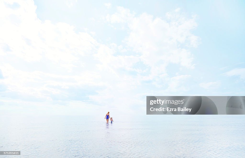 Mother and young son wading in the shallow water.