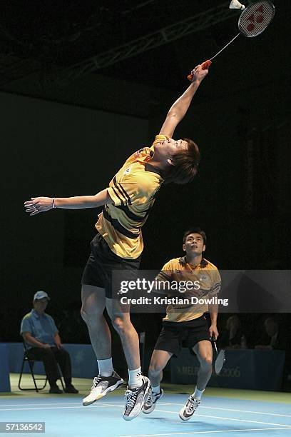 Kien Keat Ko of Malaysia makes an overhead smash against Anthony Ian Clark and Robert James Blair of England during the gold medal mixed team...