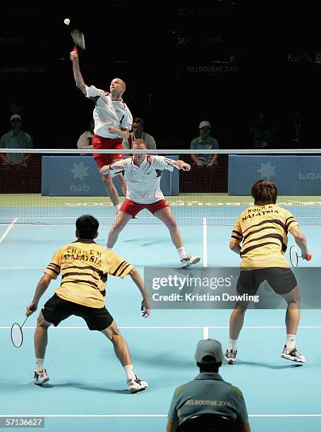 Robert James Blair of England makes an overhead smash over team-mate Anthony Ian Clark against Chong Ming Chan and Kien Keat Koo of Malaysia during...