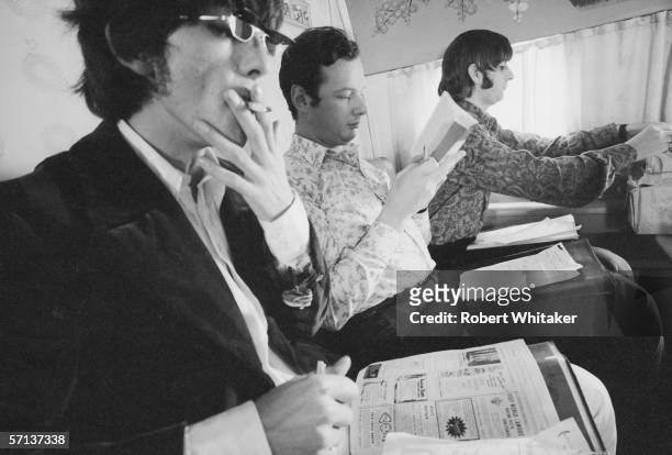 Beatles' manager Brian Epstein sits between George and Ringo en route to Manila in the Philippines, during the band's Asian tour, 4th July 1966.