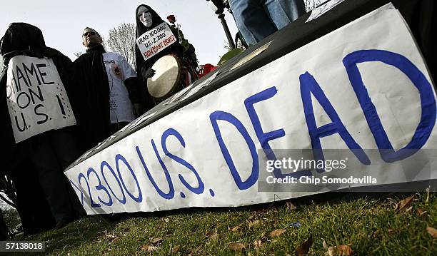 Peace activists stand over a mock casket during an anti-war rally near the National Mall before marching to the Pentagon March 20, 2006 in...