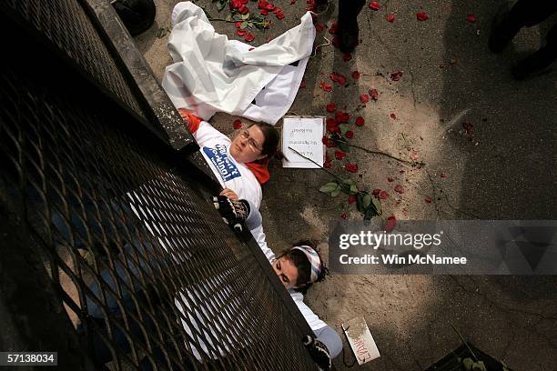 Protesters crawl underneath a barricaded police line while seeking an audience with U.S. Secretary of Defense Donald Rumsfeld to express their views...