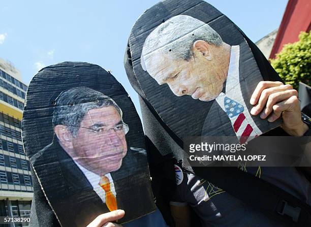 Estudiantes portan cartones con los rostros del presidente electo de Costa Rica, Oscar Arias, y el presidente de Estados Unidos, George Bush, el 20...