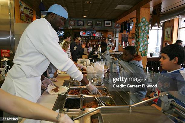Reggie Evans of the Denver Nuggets joins students from Columbine Elementary to make burritos at Illegal Pete's restaurant as part of the Nuggets eat...