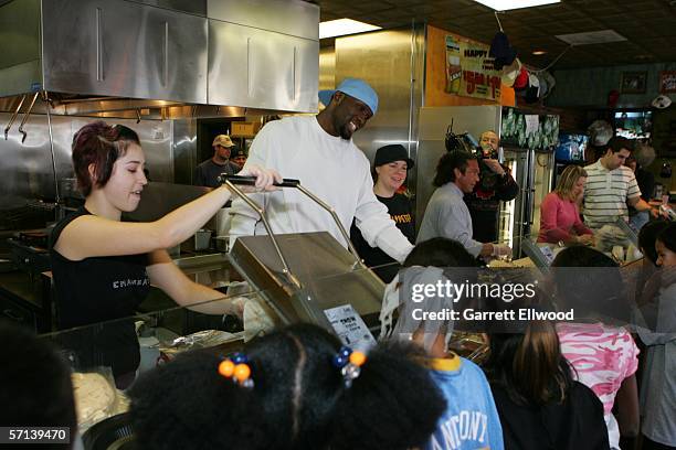 Reggie Evans and strength and conditioning coach Steve Hess of the Denver Nuggets join students from Columbine Elementary to make burritos at Illegal...