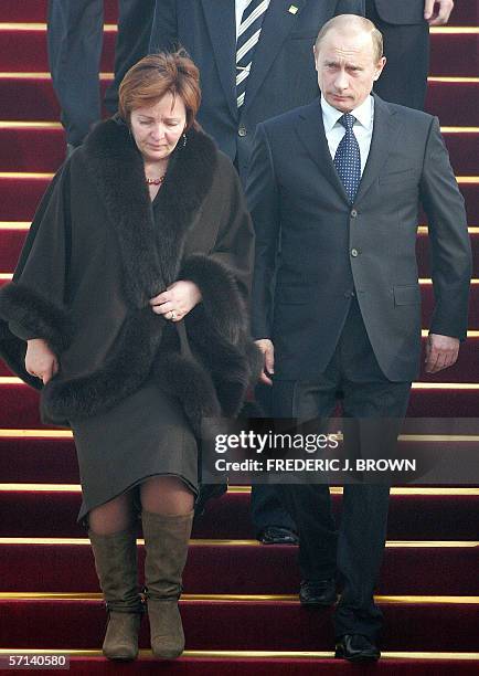 Visiting Russian President Vladimir Putin and his wife Lyudmila walk down the stairs on arrival at the airport in Beijing, 21 March 2006. President...