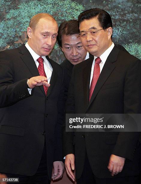 Visiting Russian President Vladimir Putin explains something to a translator as Chinese President Hu Jintao listens during a signing ceremony at the...