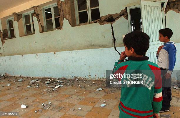 Children look at the damage caused in a school by an earthquake 21 March 2006 in the town of Bejaia after the earthquake hit the nearby town of...