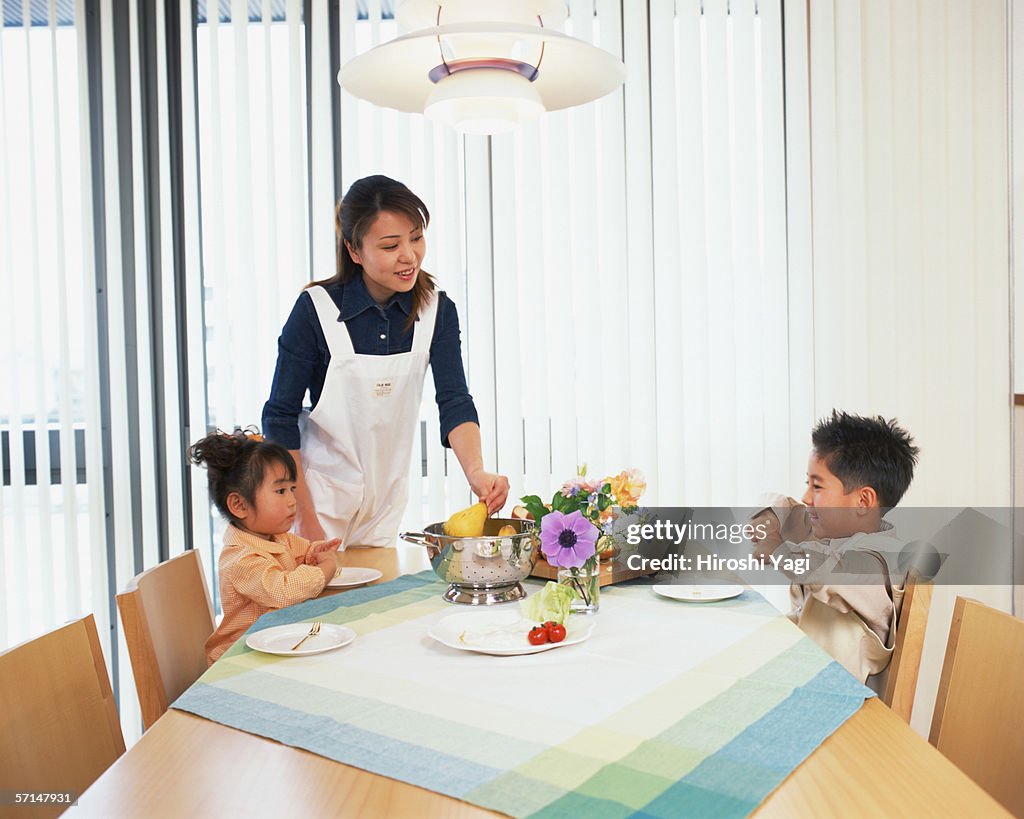 A mother serving breakfast to her children