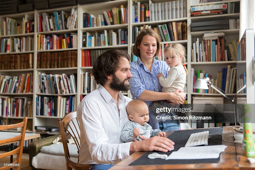 Young family with two children in home office