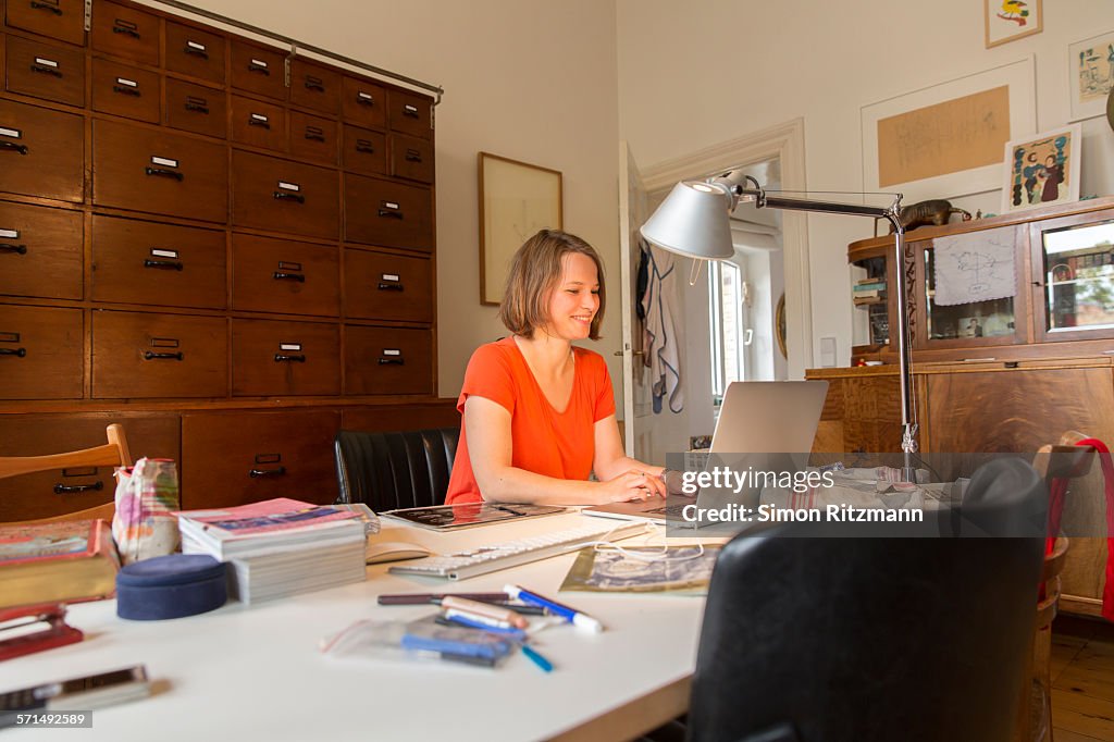 Young female designer working in home office