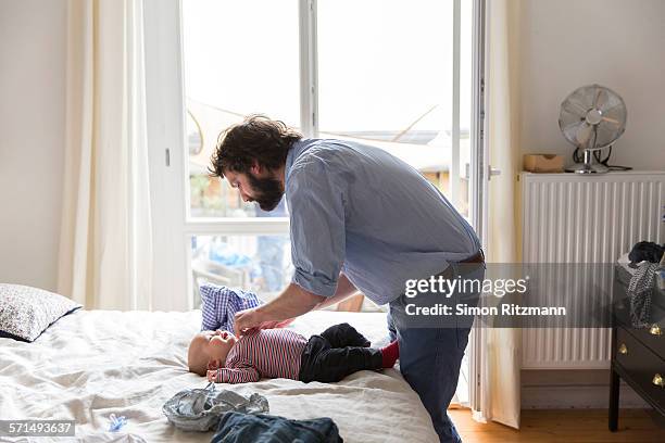 father taking care of baby son at home - bending over stock pictures, royalty-free photos & images