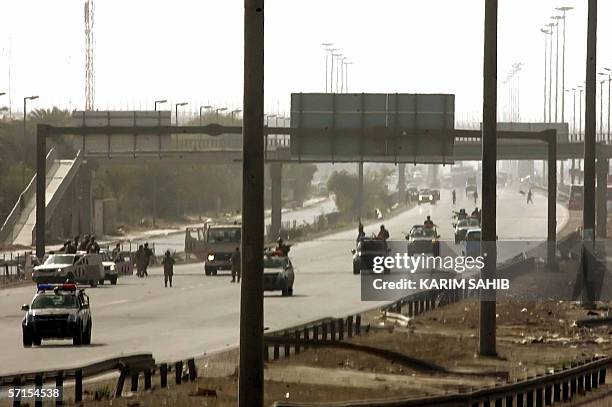 Iraqi police commandos secure a highway west of Baghdad, where insurgents ambushed Shiite civilians coming back from the southern holy city of...