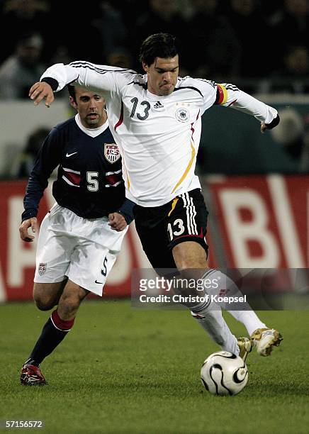 Michael Ballack of Germany runs with the ball and is followed by Kerry Zavagnin of the during the international friendly match between Germany and...