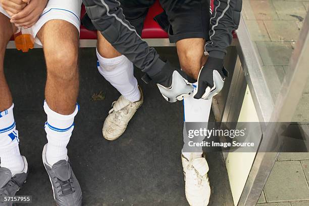 goalkeeper adjusting shin guard - shin guard stock pictures, royalty-free photos & images