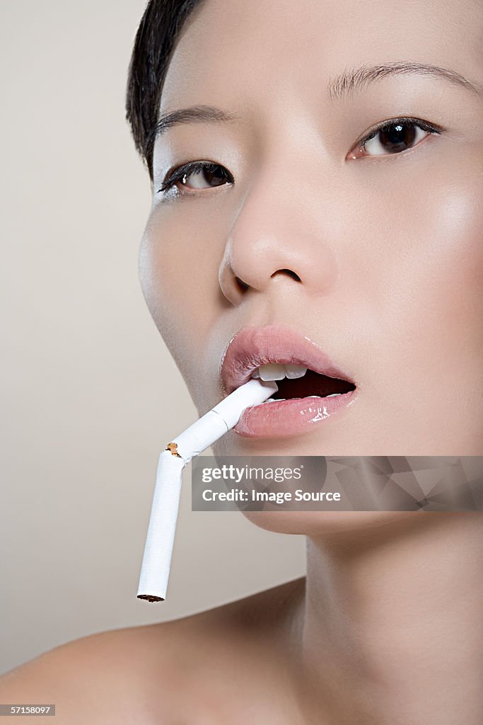 Woman with broken cigarette in her mouth