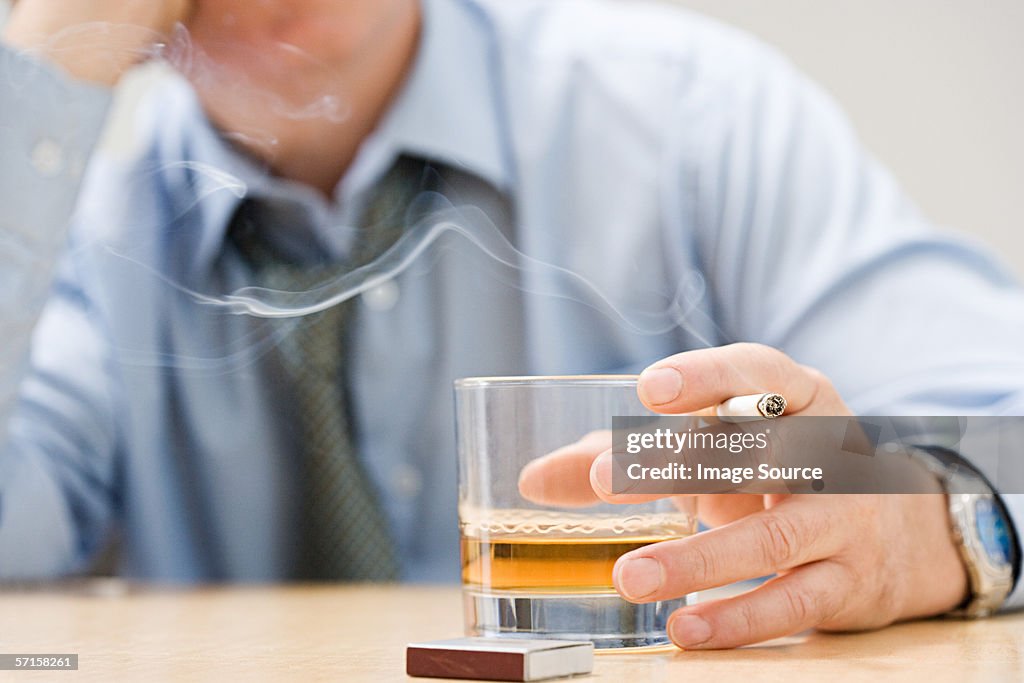 Man drinking whisky and smoking
