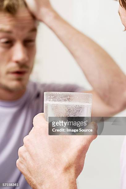 man with glass of soluble aspirin - effervescent tablet stock pictures, royalty-free photos & images