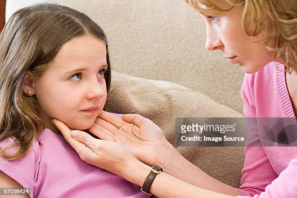mother checking daughter's throat - thyroid exam stock pictures, royalty-free photos & images