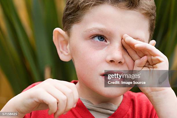 boy rubbing his eye - alleen één jongen stockfoto's en -beelden