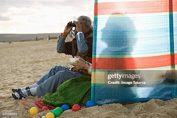 indian couple at the beach - beach shelter stockfoto's en -beelden
