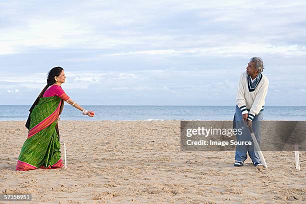 couple playing cricket on the beach - man with cricket bat stock pictures, royalty-free photos & images