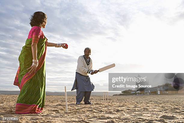 couple playing cricket on the beach - cricket lover stock pictures, royalty-free photos & images