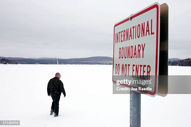 Border Patrol Agent Andrew Mayer walks onto a frozen lake during a patrol on the lake that is split between Canadian territory to the right and the...