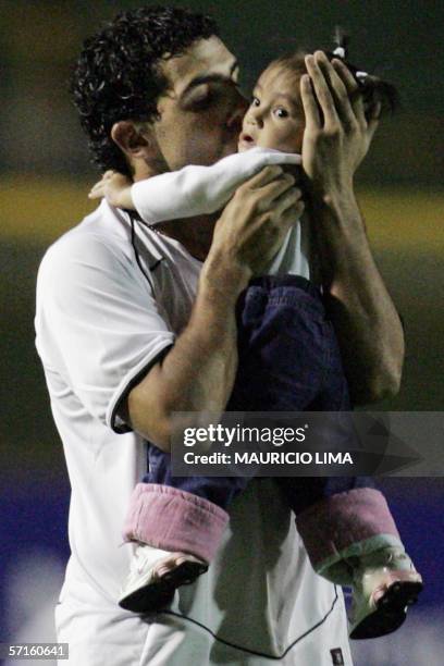 Argentine's forward Carlos Tevez, of Brazil's Corinthians, kisses his daugther Florencia prior to the start of a football match against Mexico's...