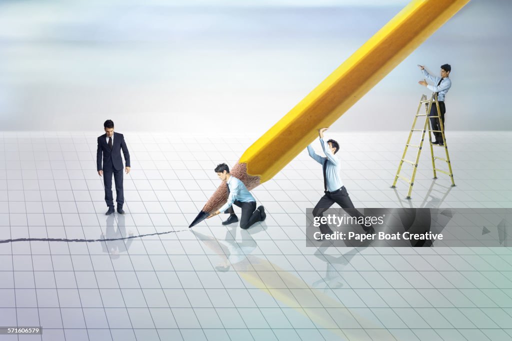 Group of businessmen holding a giant pencil