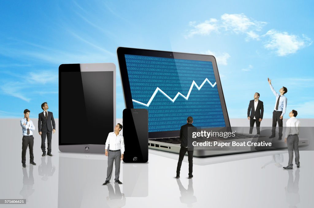Group of men looking at a laptop with stocks mark