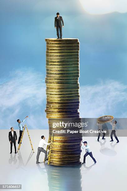 man standing on a high stack of gold coins - cash contest stock pictures, royalty-free photos & images