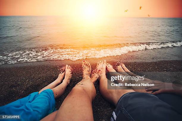 family of four relaxing on beach - rebecca da costa - fotografias e filmes do acervo