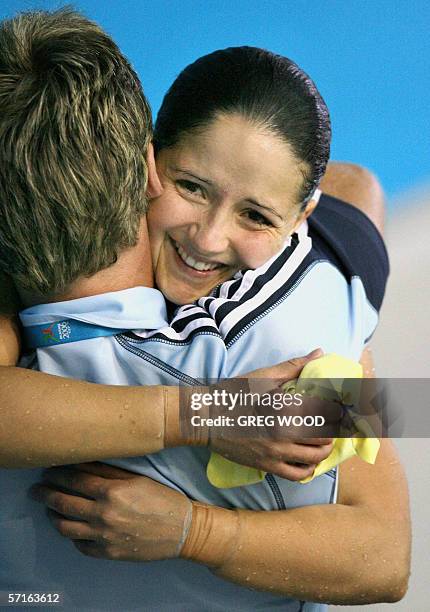 Australia's Loudy Tourky hugs her coach Matt Anderson after winning the Commonwealth Games women's 10m platform final at the Melbourne Sports and...