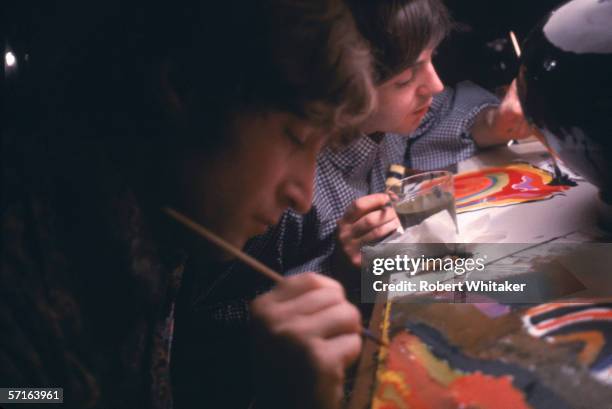 John and Paul while away the hours between shows with a spot of painting at the Tokyo Hilton, during the Beatles' Asian tour, 28th June 1966. All...