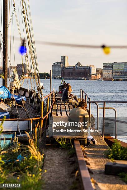 people relaxing on boat pier at ndsm - ndsm stockfoto's en -beelden