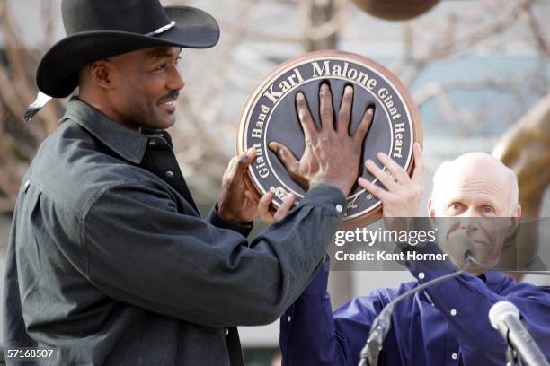 Retired power-foward Karl Malone fits his hand into a mold at the unveiling of the statue commissioned by the Utah Jazz owner Larry H. Miller on...